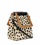 A stylish, boxy handbag with a cream-colored base and irregular black leopard spots, complemented by a geometric wooden handle