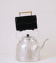 Editorial photo of black vegan structured bag with with top-stitching and gold sleek top handle