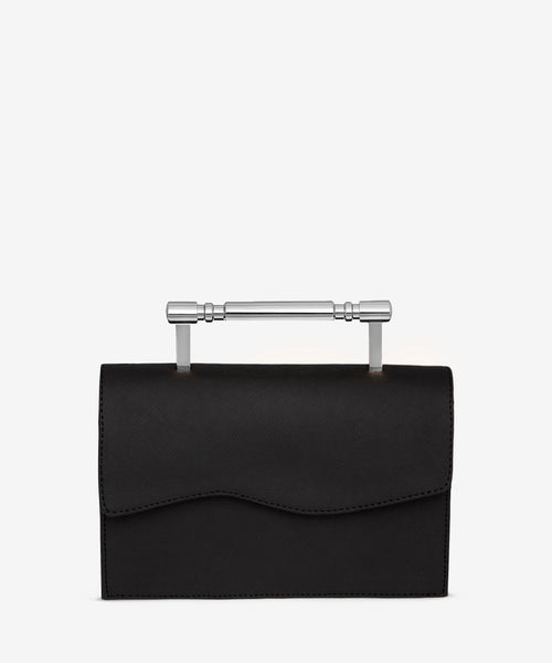 Elegantly crafted black Saffiano leather handbag with a bold, silver Art Deco-inspired top handle, offering a timeless and sophisticated silhouette.