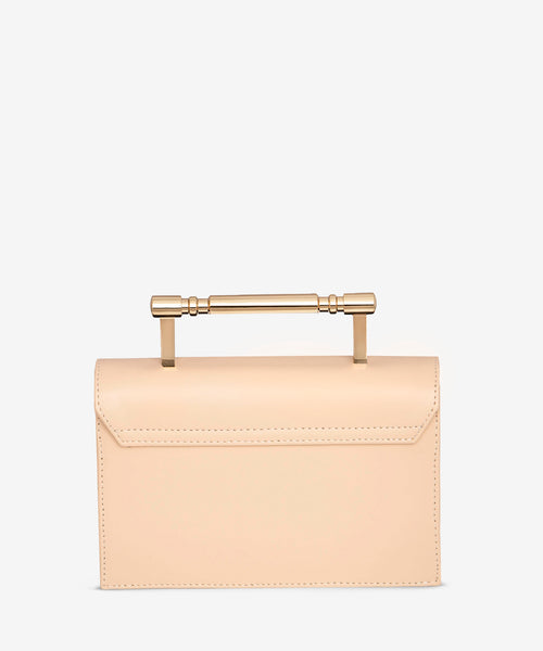 back view of luxury creme structured bag, vegan and PETA approved with gold top handle
