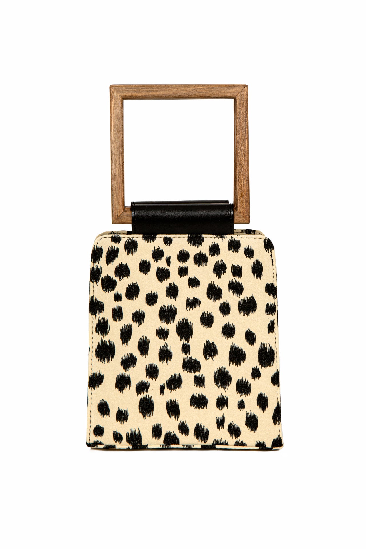 A modern animal-print handbag with a structured silhouette, black brushstroke-style spots, and a square wooden handle with a black leather accent.