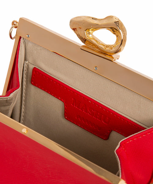 Interior of Mashu vegan handbag in red featuring a vintage silhouette with gold hardware and embossed logo.