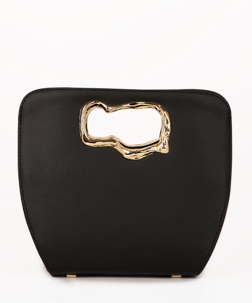 A minimalist, black leather handbag with a sculptural gold-tone handle opening, featuring an asymmetrical organic design.